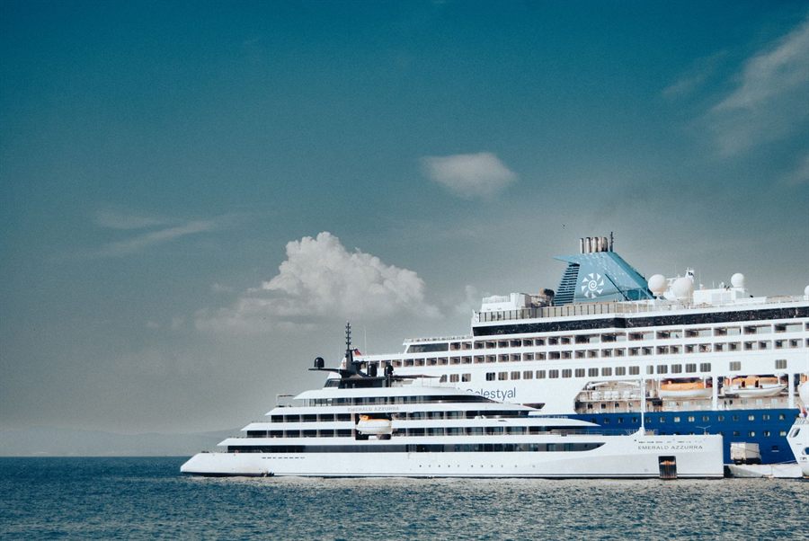 Two cruise ships anchored on calm blue water under a clear sky