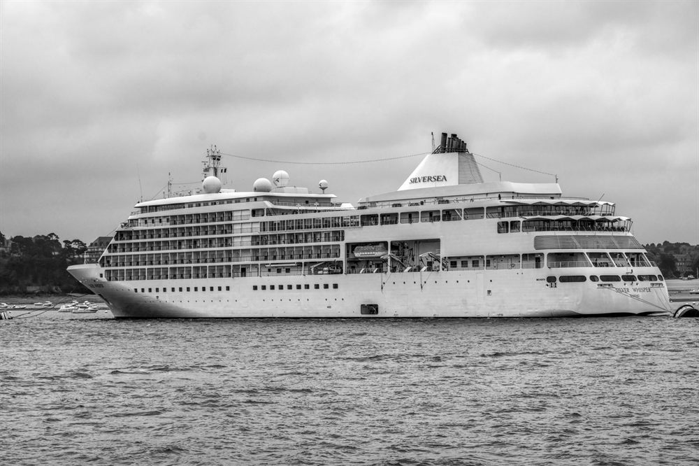 Black-and-white photo of a cruise ship sailing off the coast of Brittany