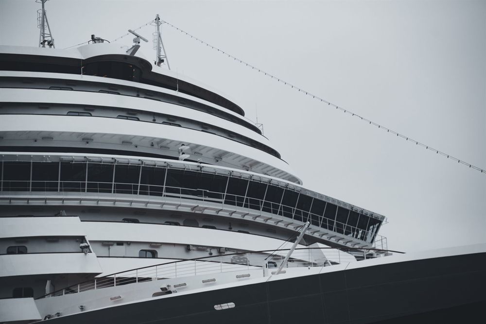 Curving decks and balconies of a modern cruise ship rising above the dock